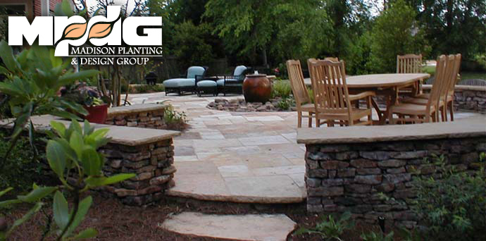 Flagstone patio with stacked stone seating walls and an outdoor dining table