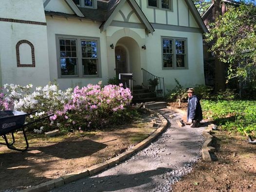 MPDG crew member building a new garden path beside blooming azaleas